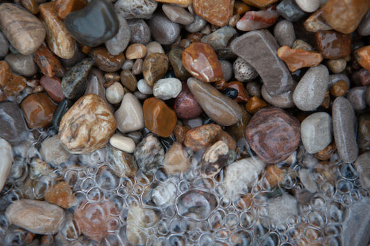 shiny beach rocks under the lake's bubbling wave