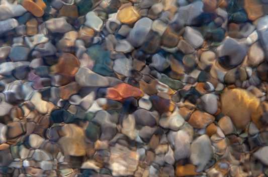 Blurred photo of rocks underneath the water on the shores of Lake Huron