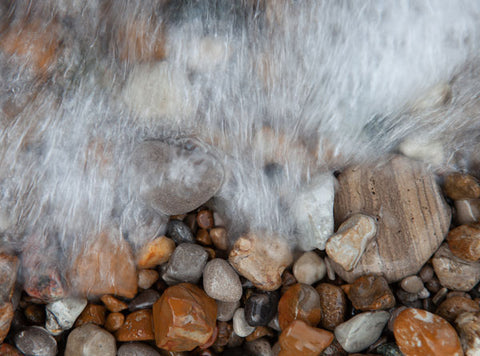 Beach Rocks under water with wave cresting over them 