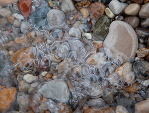 beach rocks underwater with bubbles on top of them