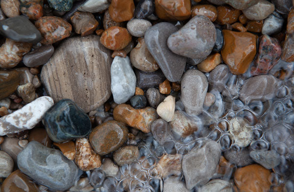 Neutral Tones Beach pebbles along the shore of the lake with water bubbles on top of them