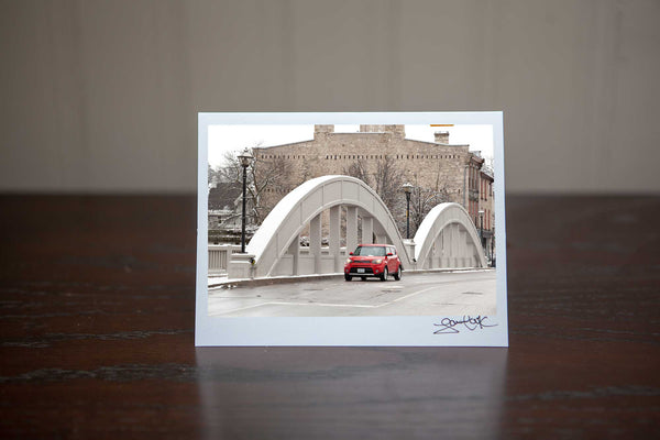 Christmas Greeting Card featuring ' Cambridge Soul'  a photograph of Downtown Galt Cambridge Main St Bridge with a red Kia Soul driving over the bridge Photo by Cambridge Ontario Photographer Laura Cook of Vision Photography