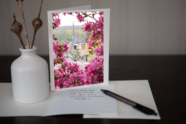 photo greeting card featuring the original photograph "Spring on Main" which is a view of Main Street downtown Galt encircled by spring flower blossoms by photographic artist Laura Cook 
