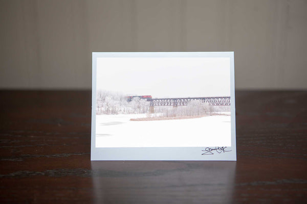 Hand made Photo greeting card perfect for Christmas that features 'WinterCrossing' a photo of a red CN train crossing an elevated train bridge above the Grand River in Cambridge Photo by Cambridge Ontario Photographer Laura Cook of Vision Photography 